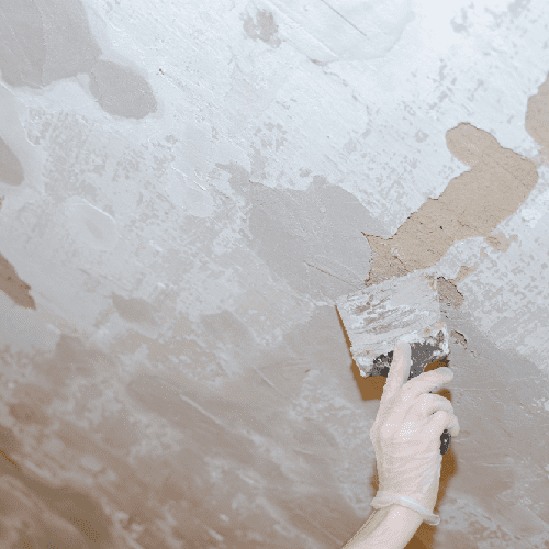 a worker puttying holes in the walls with a tool a worker puttying holes in the walls with a tool
